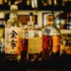 three Japanese whisky bottle are placed at the bar counter