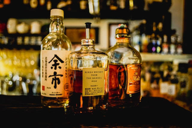 three Japanese whisky bottle are placed at the bar counter