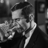 A man drinking a glass of whisky