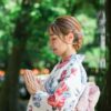 Japanese woman in kimono paying homage to the gods at a shrine